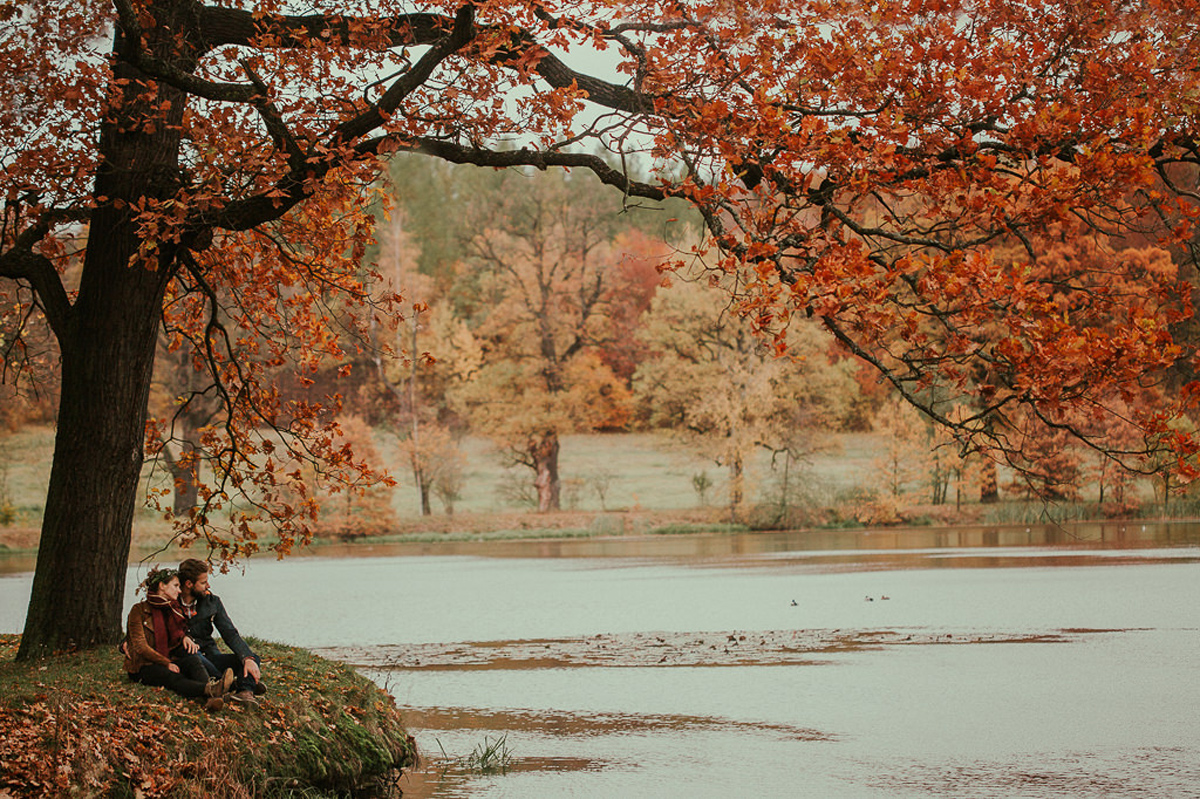 obraz pary nad jeziorem wsrod jesiennych drzew